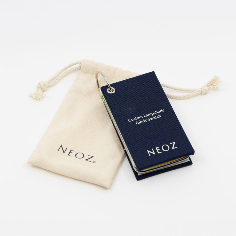 NEOZ Custom Lampshade Fabric Swatch pack closed beside branded cotton drawstring pouch